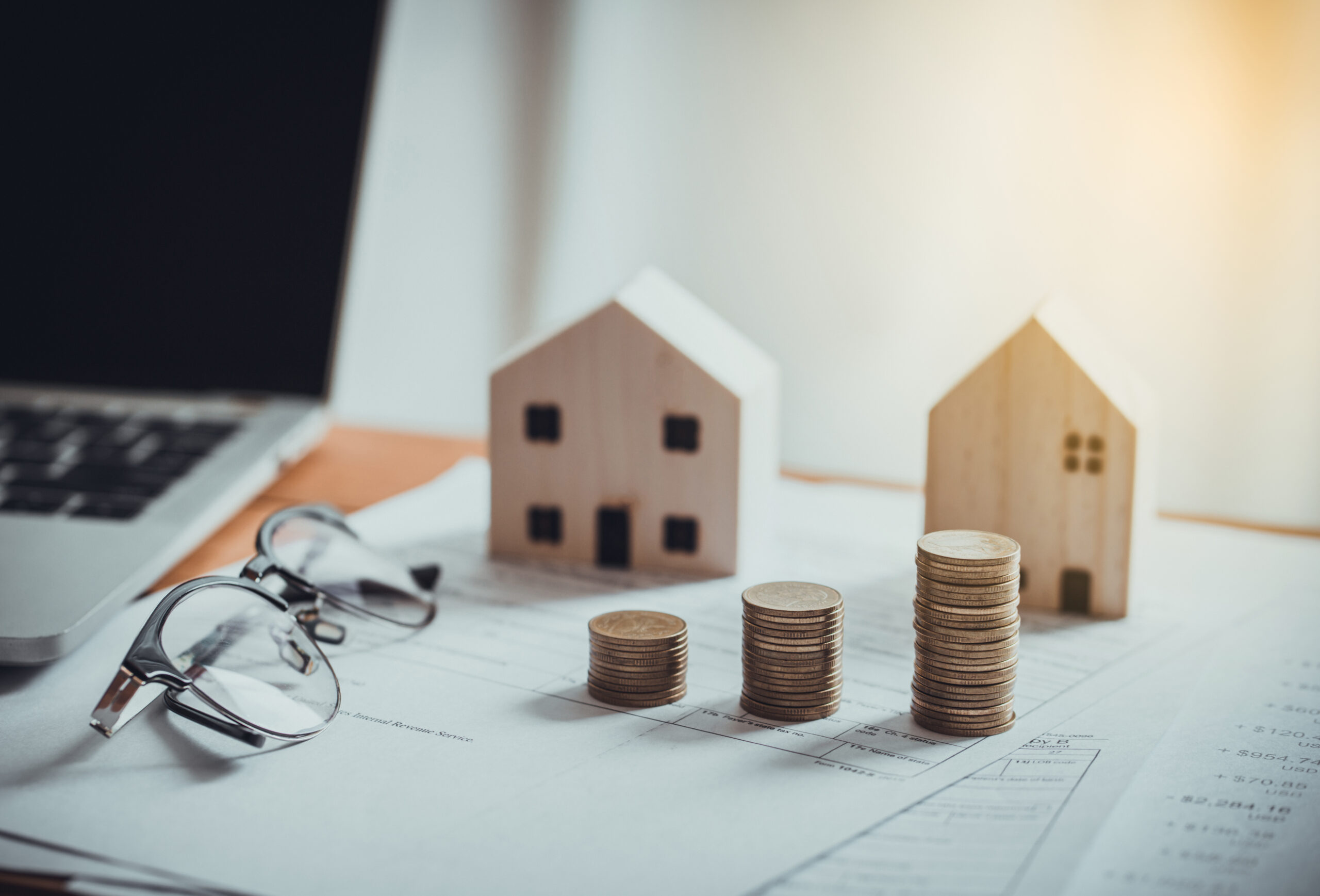 Stack of Coins ,Income Tax Raise Concept. Stack of Coins with House model, tax form, glasses and tablet, Income Tax Raise Concept.